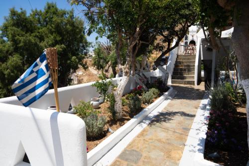 a house with a greek flag in a garden at Mama's Pension in Agios Stefanos