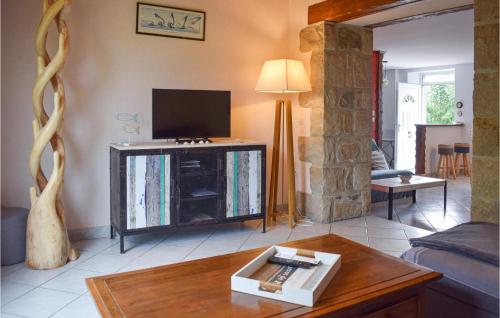 un salon avec une télévision et une table dans l'établissement Cozy Home In Pleubian With Wifi, à Pleubian