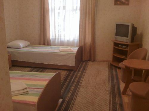 a small room with two beds and a television at Jomas 24 in Jūrmala