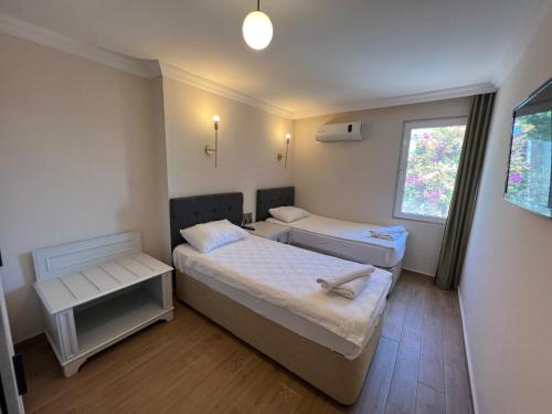 um pequeno quarto com 2 camas e uma janela em Moonshine Hotel & Suites em Bodrum City