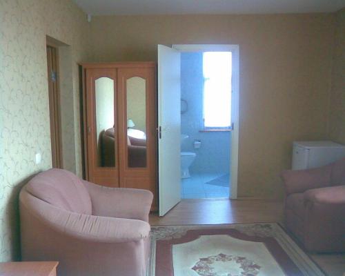 a living room with a chair and a sliding door at Jomas 24 in Jūrmala