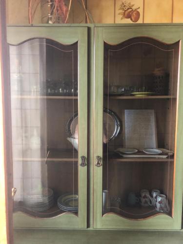 a green cabinet with plates and dishes in it at Bellorizzonte Colleferro in Colleferro