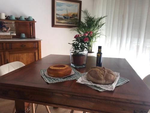 a wooden table with two loaves of bread and a bottle of wine at Ría de Navia in Navia