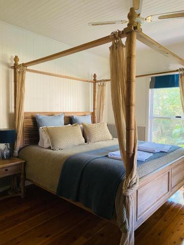 a bedroom with a canopy bed in a room at Telegraph Retreat Cottages in Telegraph Point