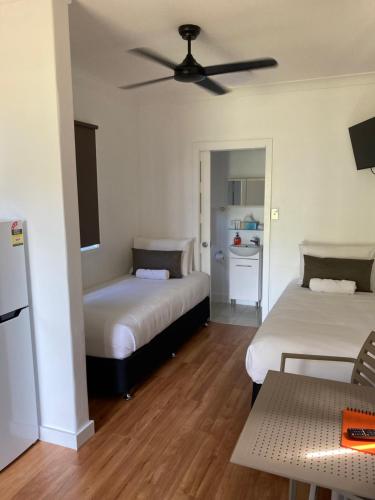 a bedroom with two beds and a ceiling fan at Bali Hai Child Free Holiday Park Mission Beach in Mission Beach
