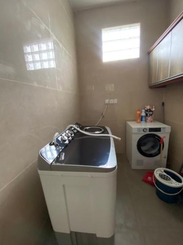 Il comprend une petite cuisine avec un évier et un lave-linge. dans l'établissement Villa Ad Homestay, à Ampang