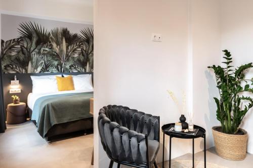 a bedroom with a bed and a black chair at PAME Wild in Athens