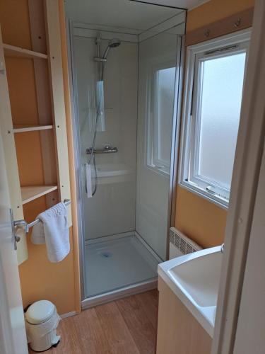 Un baño con ducha con puerta de cristal. en Vakantie bij 17, en Serooskerke