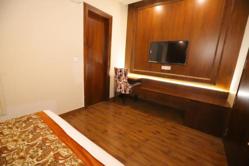 a bedroom with a bed and a desk with a tv at IP Royal Hotel - New Delhi in New Delhi