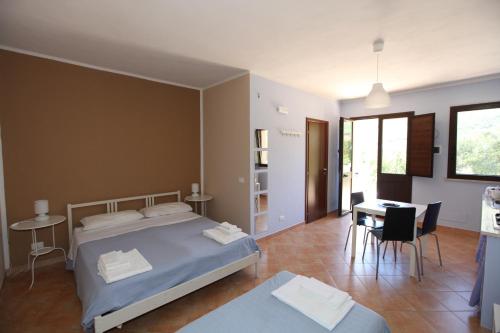 1 dormitorio con 1 cama, mesa y sillas en Le Terrazze Su Fraginesi, en Castellammare del Golfo