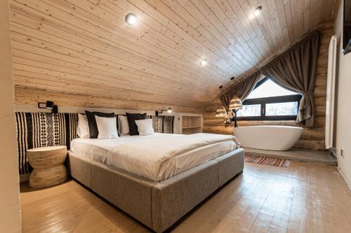 a bedroom with a large bed and a bath tub at Casa din Vale in Săcuieu