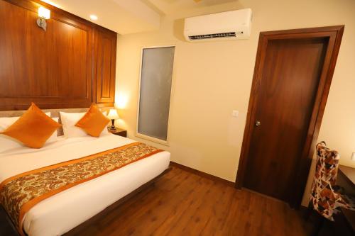a hotel room with a bed with orange pillows at IP Royal Hotel - New Delhi in New Delhi