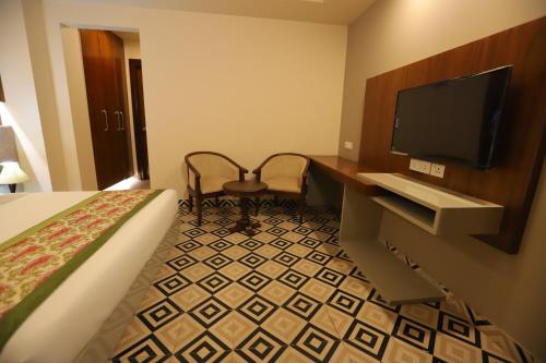 a hotel room with a bed and a flat screen tv at IP Royal Hotel - New Delhi in New Delhi