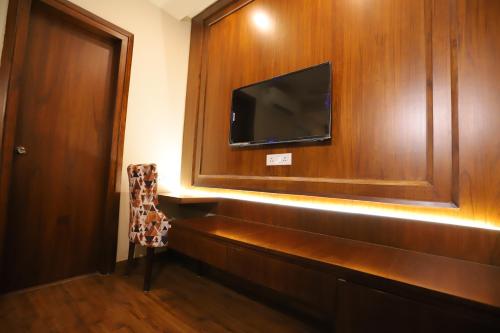 a room with a tv and a wooden wall at IP Royal Hotel - New Delhi in New Delhi