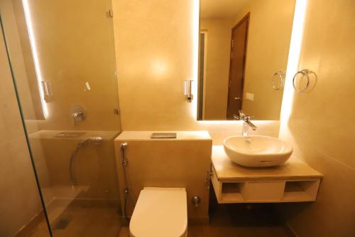 a bathroom with a toilet and a sink and a shower at IP Royal Hotel - New Delhi in New Delhi