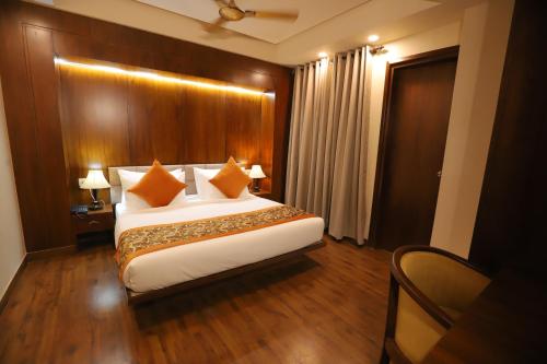 a bedroom with a large bed with a wooden wall at IP Royal Hotel - New Delhi in New Delhi