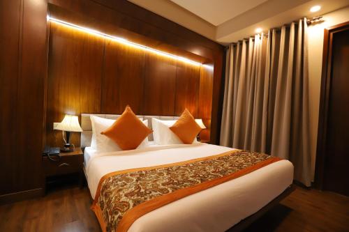 a hotel room with a large bed with orange pillows at IP Royal Hotel - New Delhi in New Delhi