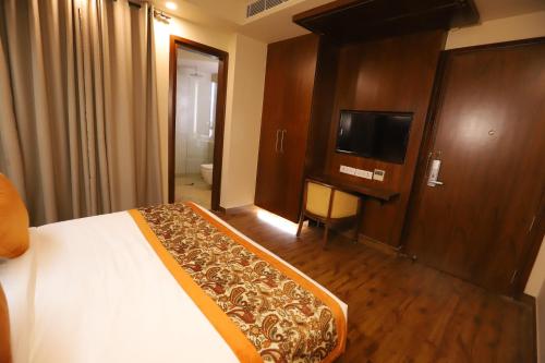 a bedroom with a bed and a flat screen tv at IP Royal Hotel - New Delhi in New Delhi