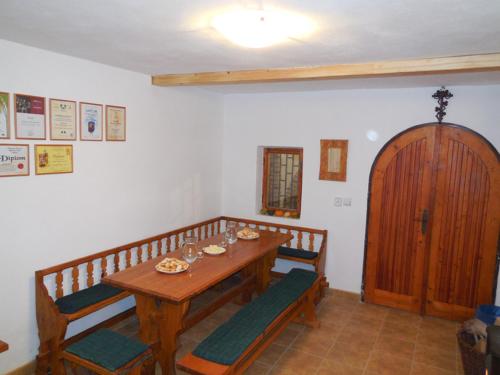 a dining room with a wooden table and benches at Vojtěch Jestřáb - rodinné vinařství in Mutěnice