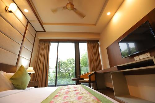a hotel room with a bed and a large window at IP Royal Hotel - New Delhi in New Delhi