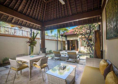 an outdoor patio with a table and chairs at Pearl of Trawangan in Gili Trawangan