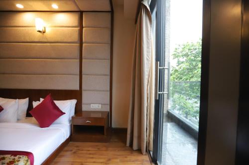 a bedroom with a bed and a window with a balcony at IP Royal Hotel - New Delhi in New Delhi