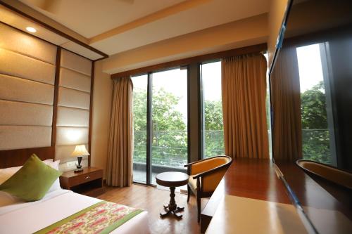 a hotel room with a bed and a desk and window at IP Royal Hotel - New Delhi in New Delhi