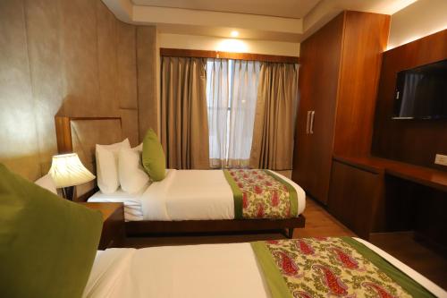 a hotel room with two beds and a television at IP Royal Hotel - New Delhi in New Delhi