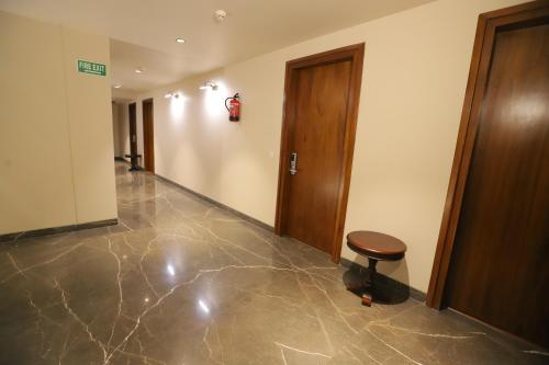 an empty hallway with a stool and a door at IP Royal Hotel - New Delhi in New Delhi