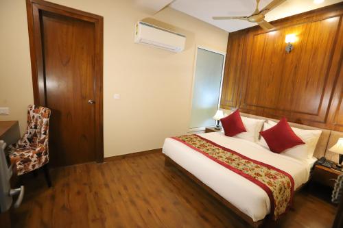 a hotel room with a large bed with red pillows at IP Royal Hotel - New Delhi in New Delhi
