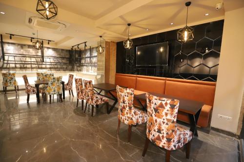 a restaurant with tables and chairs and a bar at IP Royal Hotel - New Delhi in New Delhi