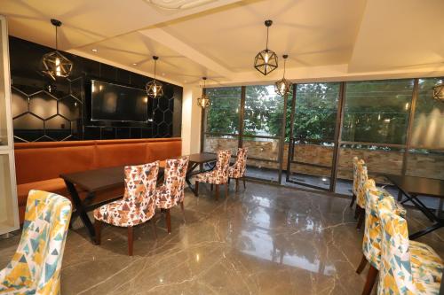 a dining room with tables and chairs and windows at IP Royal Hotel - New Delhi in New Delhi