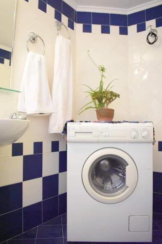 a bathroom with a washing machine with a plant on it at C' est la vie in Nafplio