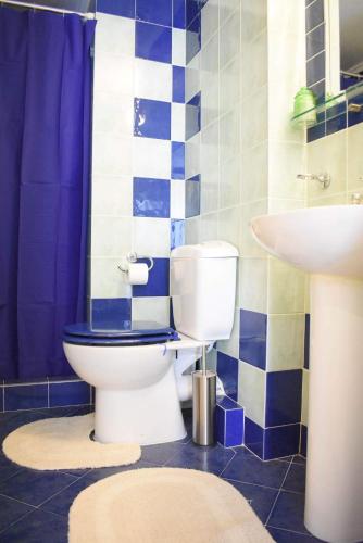 a blue and white bathroom with a toilet and a sink at C' est la vie in Nafplio