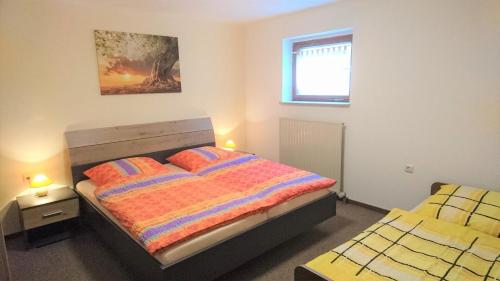 a bedroom with a bed with two pillows and a window at Gemütliche FeWo am Hülfensberg und dem Grünen Band in Döringsdorf