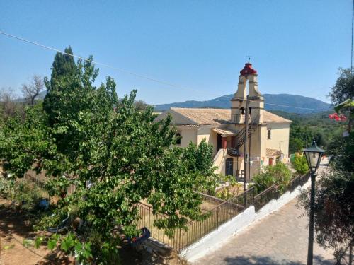a church on a hill with a fence at Village House in Ágios Matthaíos
