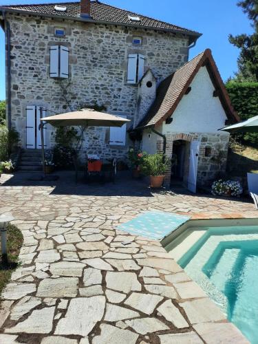 une maison et une piscine devant une maison dans l'établissement Chambres d'hôtes Le Moulin Juste Ambierle - Loire, à Ambierle