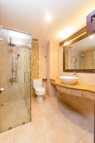 a bathroom with a shower and a toilet and a sink at Gold Coast Da Nang Hotel in Danang