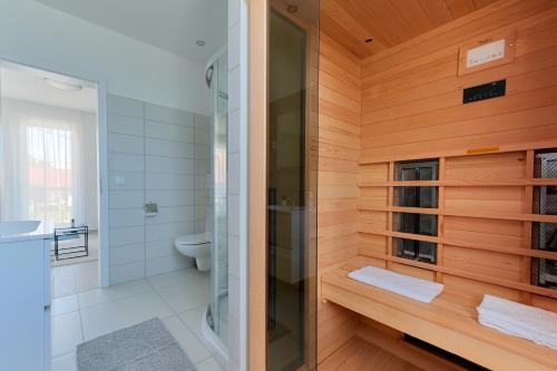 a bathroom with a glass shower and a toilet at Villa Oliver Zalakaros in Zalakaros