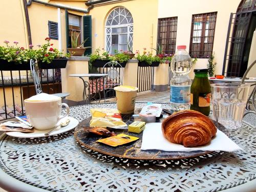 una mesa con un plato de pan y café y una taza en B&B The Lux en Florence