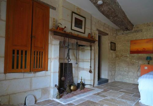 um quarto com uma parede de pedra e uma lareira em Ferme du bois de Veude em Anché