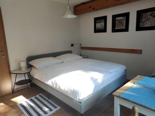 um quarto com uma cama branca e uma mesa em Nad Lahinjo em Gradac