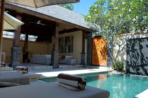 a swimming pool next to a house at Pearl of Trawangan in Gili Trawangan