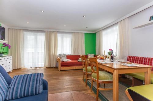 a living room with a table and a couch at Haus Garten An der Sonne in Niedernsill