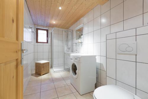 W białej łazience znajduje się pralka. w obiekcie Ferienhaus Engstler w mieście Schruns
