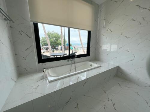 a white bathroom with a window and a bath tub at Pearl of Samui Resort in Koh Samui 