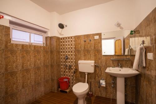 a bathroom with a toilet and a sink at Rainbow Hostelier in Leh