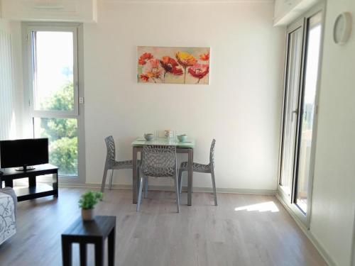 - un salon avec une table, des chaises et un tableau dans l'établissement Studio à La Rochelle : Vue Océan & Parking - FR-1-551-32, à La Rochelle