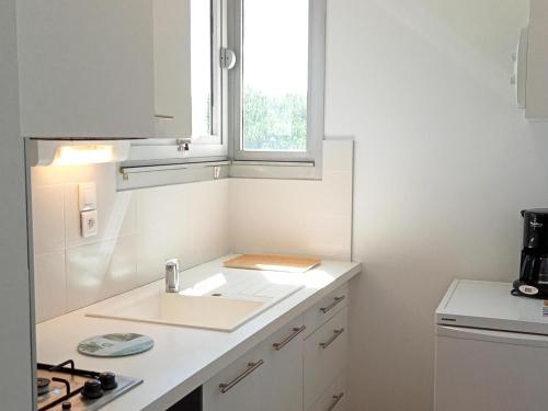 une cuisine blanche avec un évier et une fenêtre dans l'établissement Studio à La Rochelle : Vue Océan & Parking - FR-1-551-32, à La Rochelle