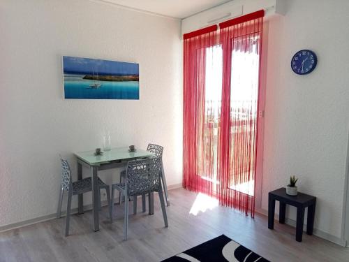 une salle à manger avec une table et des chaises et une fenêtre dans l'établissement Studio lumineux pour 2, vue océan avec parking privatif à La Rochelle - FR-1-551-40, à La Rochelle